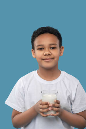Cute friendly boy with glass of milkの写真素材
