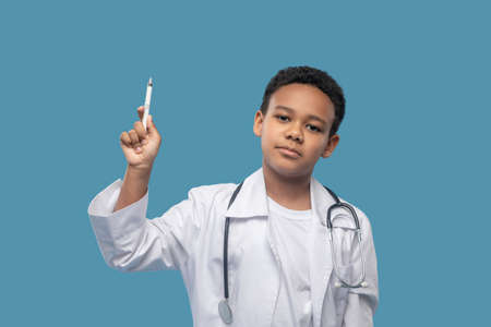 Boy in white coat showing pointer upの写真素材