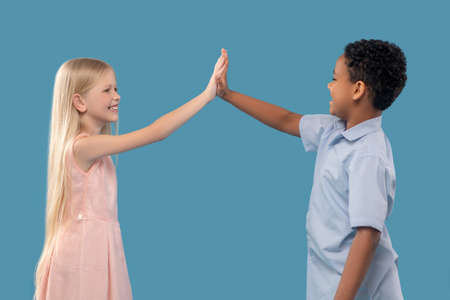 Boy and girl with outstretched hand touching palms