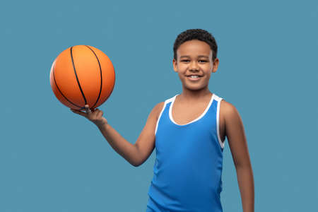 Smiling boy holding ball on fingersの写真素材
