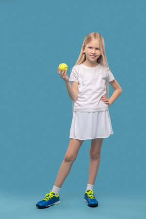 Girl in white sportswear with tennis ballの写真素材