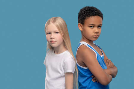 Girl and boy in sportswear on blue backgroundの写真素材