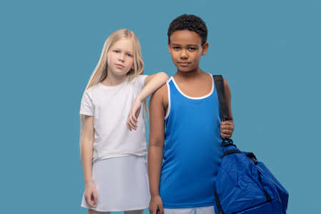 Girl touching boy with gym bagの写真素材