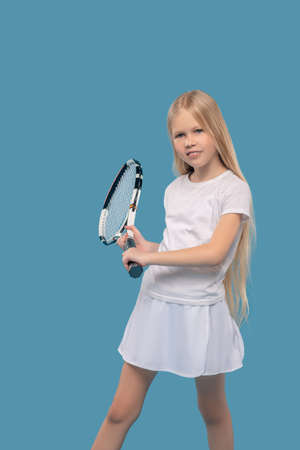 Girl in sportswear exercising with tennis racketの写真素材