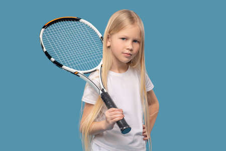 Girl holding tennis racket on her shoulderの写真素材