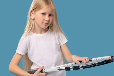 Girl touching stringarea face of tennis racket with fingersの写真素材