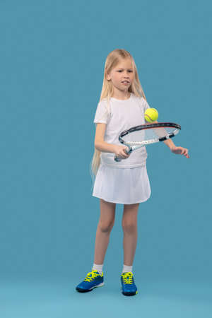 Girl exercising with tennis racket and ballの写真素材
