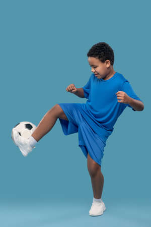 Dark skinned boy moving with soccer ballの写真素材