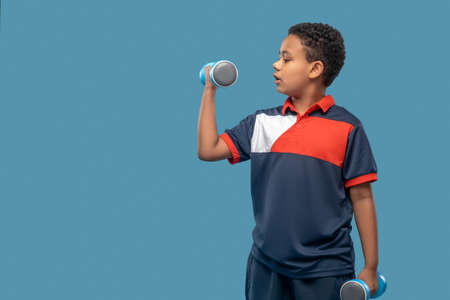 Serious african american boy doing dumbbell exerciseの写真素材