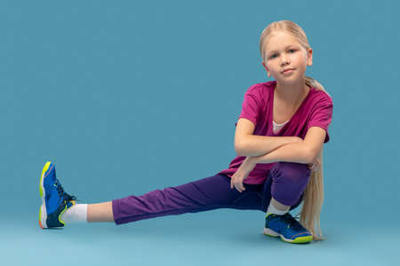 Girl crouching with her leg out to sideの写真素材