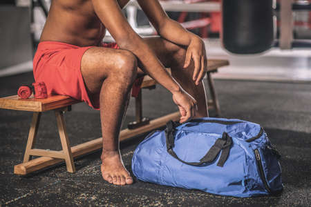 A young sportsman in a changing room before the workoutの写真素材