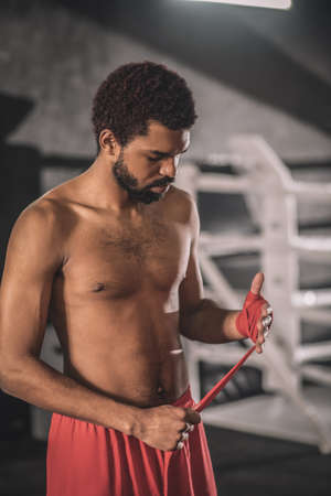 Kickboxer typing a bandage on his hand before the workoutの写真素材
