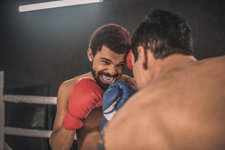 Two kickboxers fighting on a boxing ring and looking aggressiveの写真素材