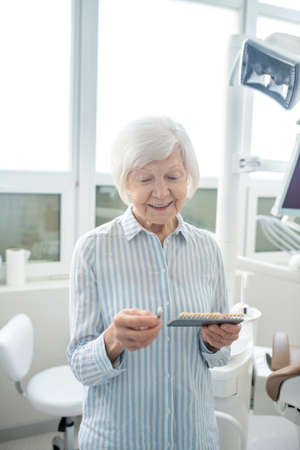 Senior woman at the dentists office with denture in handsの写真素材
