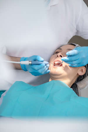 Dentist working on patients teeth restoration and making dental fillingの写真素材