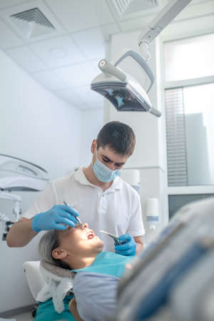Male dentist working with a patient and making teeth restorationの写真素材