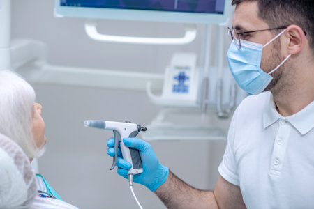 Dentist at work. Dentist in sterile gloves working with a patient in his officeの写真素材