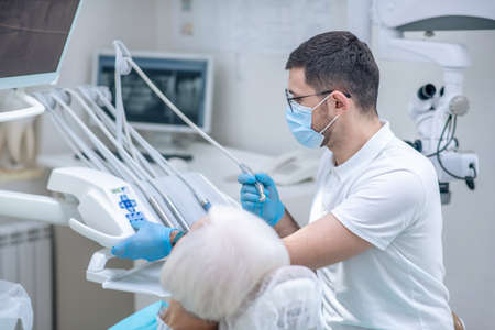 Dentist restoring teeth to the senior female patient