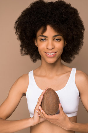 A young pretty curly-haired mulatta with a coconutの写真素材