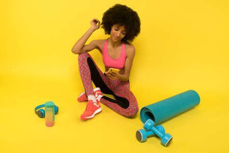 A young pretty curly-haired mulatta resting after a workoutの写真素材