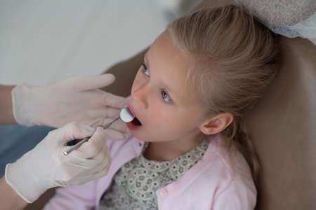 Small blonde girl being examoined by the pediodontistの写真素材