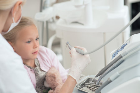 A little blonde child having teeth treatment at the dentistsの写真素材