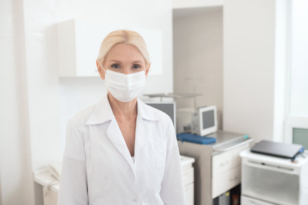 A blonde female doctor wearing a protective maskの写真素材
