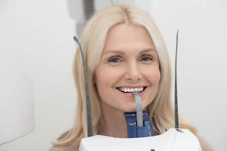 A blonde woman having dental treatment and feeling positiveの写真素材