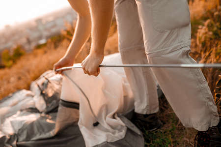 A young man pitching the tent on the hillの写真素材
