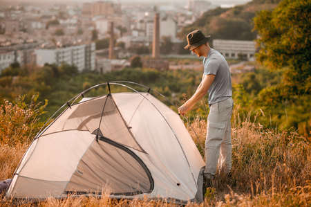 A man putting the tent and looking involvedの写真素材