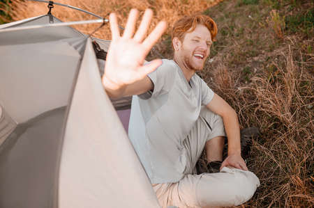 A ginger man looking joyful and stretching his handの写真素材