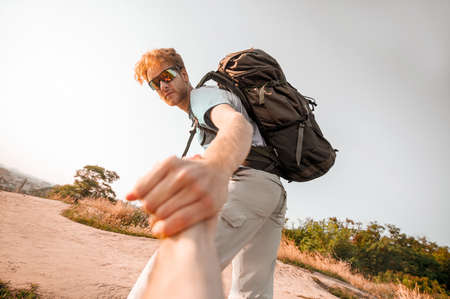 A man with a big backpack hiking and looking contentedの写真素材