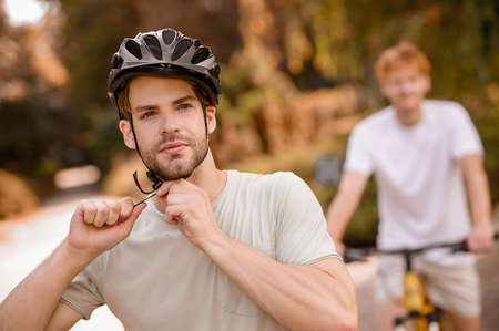 Sportsman adjusting the helmet straps before the bike rideの写真素材