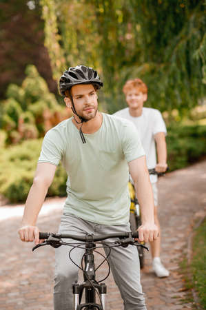 Two sporty people biking together in the parkの写真素材