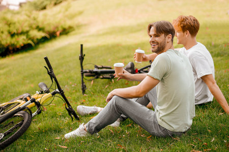 Two friends having a coffee break after their cycling trainingの写真素材