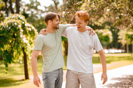 Two young adult guys rejoicing in meetingの写真素材
