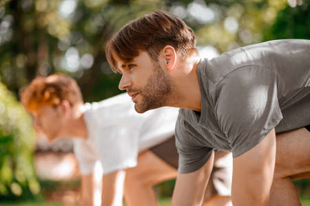 Dark-haired purposeful guy at start of run and friend