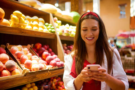 A cute young woman in a fruit storeの写真素材