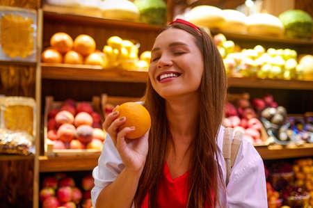 A cute young woman in a fruits storeの写真素材