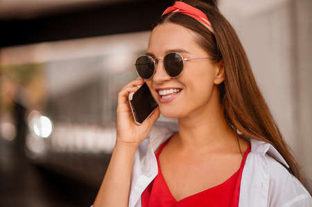 A stylish woman talking on the phone and smilingの写真素材