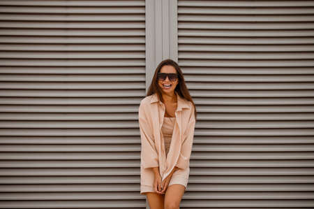 A young pretty woman in beige clothes and in sunglassesの写真素材