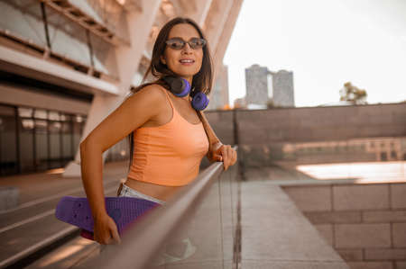 A picture of a cute girl in orange top on the urban background