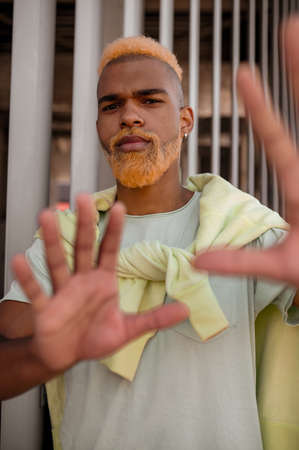 A stylish young man with dyed bearded posing for the cameraの写真素材