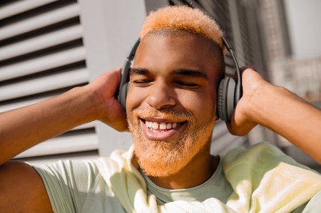 A young man in headphones listening to music and looking enjoyedの写真素材