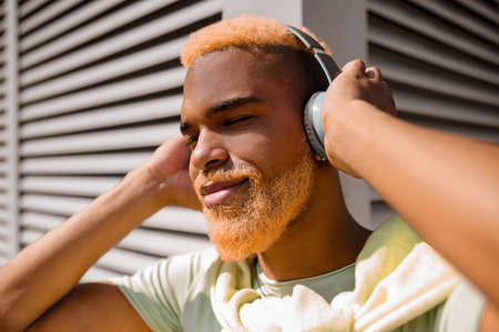 A young man in headphones listening to music and looking enjoyedの写真素材
