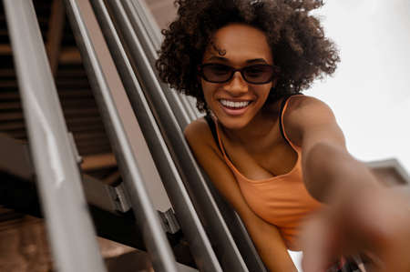 Curly-haired cute young mulatta in the city streetの写真素材