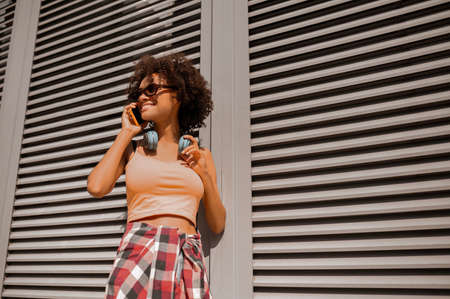 Curly-haired young woman talking on the phoneの写真素材