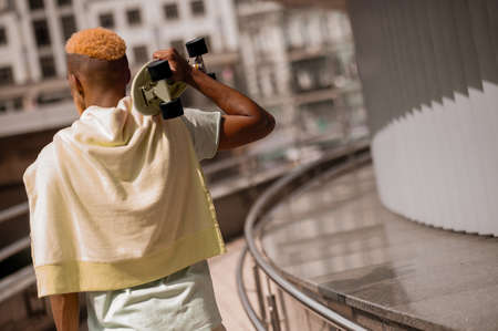 Bearded young dark-skinned man with a skateboardの写真素材