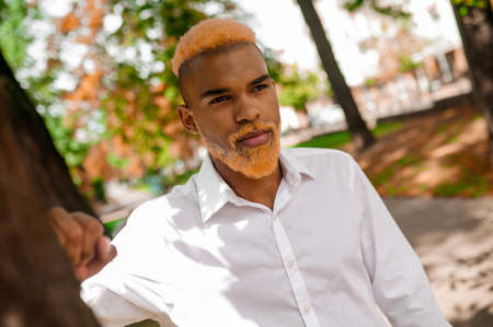 A man in white clothes in the park looking seriousの写真素材