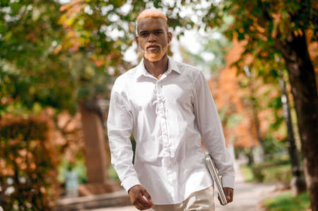 A man in white clothes in the park looking seriousの写真素材